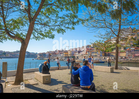 Porto Gaia Portugal, au printemps, les touristes se détendent sur une terrasse du côté de Gaia du Douro et donnent sur le front de mer de Ribeira, Porto. Banque D'Images