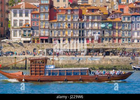 Ribeira de Porto au Portugal, sur le Douro un bateau transportant les touristes de croisière voiles Cours des bâtiments historiques situés le long de la front de Ribeira à Porto. Banque D'Images