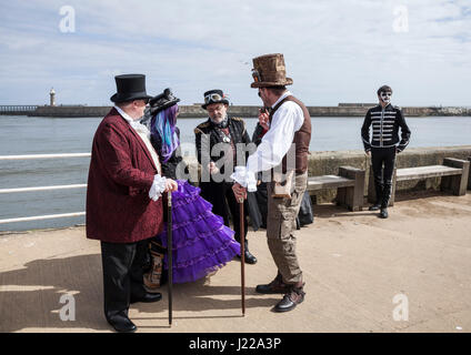 Un groupe de gens habillés en mode Steampunk chat ensemble sur le quai à Whitby, à la fin de semaine de célébrations Goth,North Yorkshire, Angleterre, Royaume-Uni Banque D'Images