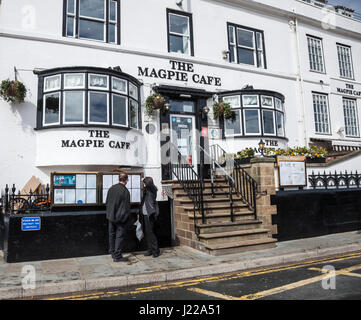 Un homme et une femme voir le menu les conseils au célèbre café Magpie à Whitby, North Yorkshire, Angleterre, Royaume-Uni Banque D'Images