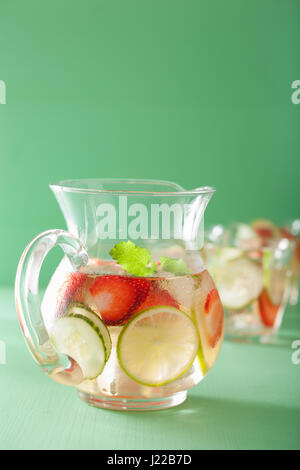 Boisson d'été rafraîchissante avec lime concombre fraise en pot et verres Banque D'Images