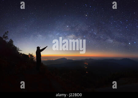 Un homme est debout à côté de la voie lactée pointant sur une étoile brillante à Doi Inthanon Chiang Mai, Thaïlande. Banque D'Images