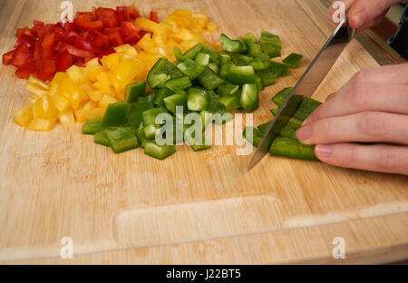 Man's hands cutting delicous paprika dans la cuisine, préparer un repas pour le déjeuner. Un plan macro. Banque D'Images