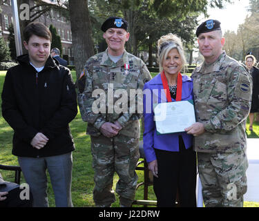 Avant le I Corps Cérémonie de passation de commandement, le général commandant de l'US Army Forces Command (FORSCOM) Le général Robert Abrams (à droite) présente la Décoration pour service civil distingué à Madeline Lanza, tandis que son mari, le 1er Corps du général commandant le général Stephen Lanza et son fils, Raymond, participer. Le 3 avril, 2017 at Joint Base Lewis-McChord, dans l'État de Washington. (Photo US Army par Sidney Lee, Enterprise Centre Multimédia, JBLM) Banque D'Images