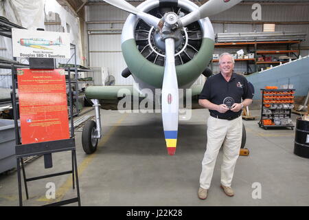 Robert Cramsie, un bénévole de restauration et d'un membre du conseil d'administration de l'Flying Sapadalure base historique, pose pour une photo avec un prix de Northrop Grumman représentants pour les efforts des bénévoles dans la restauration d'un Douglas SBD-1 Dauntless, lors d'une cérémonie au Musée de l'aviation vol Sapadalure Installation Restauration sur Marine Corps Air Station Miramar, Californie, le 21 avril. Cramsie, un ancien mécanicien d'aéronefs, a passé plus de 2 500 heures, la restauration de la dernière de son genre à l'aide d'aéronefs et pièces modèles fabriqués à partir de zéro. (U.S. Marine Corps photo par Lance Cpl. Jake McClung/ Banque D'Images