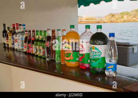 Comptoir avec un assortiment de boissons alcoolisées et non alcoolisées disponibles sur une croisière au coucher du soleil sur le Zambèze, le Zimbabwe, l'Afrique Banque D'Images