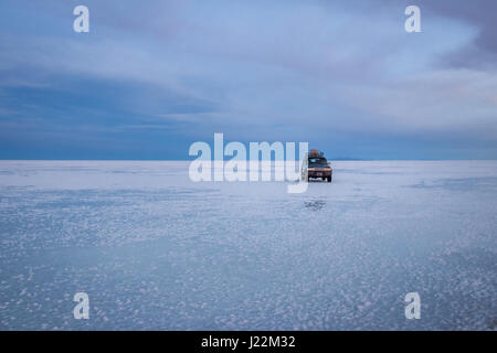 Véhicule hors route au lever du soleil à Salar de Uyuni salt flat - département de Potosi, Bolivie Banque D'Images