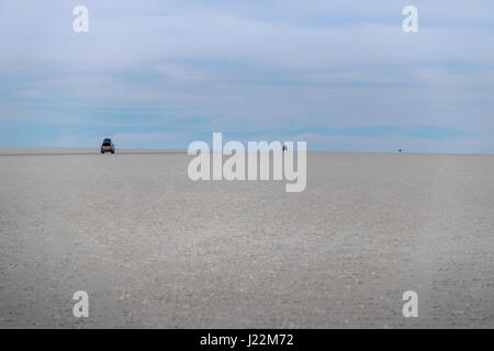 Voitures disparaissant dans horizon en Salar de Uyuni salt flat - département de Potosi, Bolivie Banque D'Images