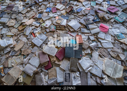 Livres sur le plancher d'un palais de la culture dans la ville fantôme de Pripyat Energetik de centrale nucléaire de Tchernobyl en Ukraine, la zone d'Aliénation Banque D'Images