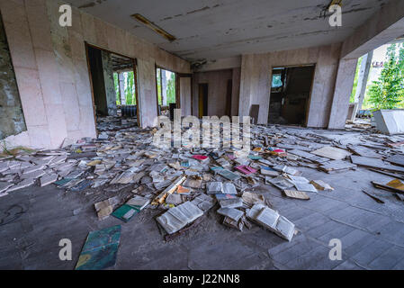 Livres sur le plancher d'un palais de la culture dans la ville fantôme de Pripyat Energetik de centrale nucléaire de Tchernobyl en Ukraine, la zone d'Aliénation Banque D'Images