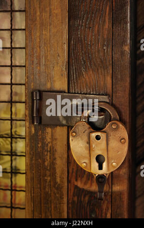 Cadenas anciens sur une porte en bois avec grille Banque D'Images