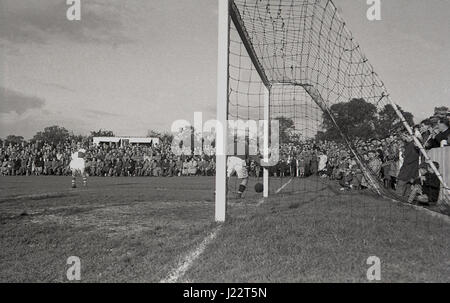 1950, en Angleterre, un match de football à Aylesbury United F.C, un club amateur formé en 1897. Gardien de but dans son objectif permet de s'assurer que le ballon va au-delà du portique. Banque D'Images