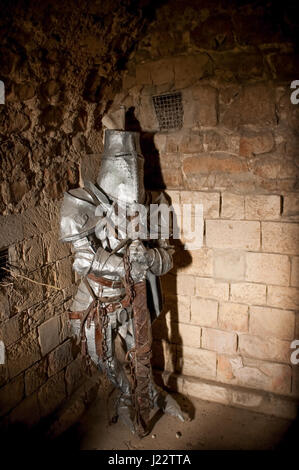 Emprisonné chevalier médiéval en armure allumé par un arbre de lumière Banque D'Images