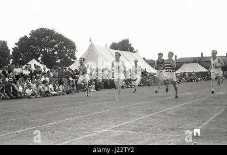 Années 1950, historiques, les athlètes masculins s'exécutant dans une course de sprint au Buckinghamshire Championnats Amateur Athletic Association (AAA), Angleterre, Royaume-Uni. Banque D'Images