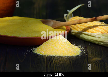 Tas de maïs, polenta et d'un épi de maïs mis sur table en bois dans la lumière naturelle Banque D'Images