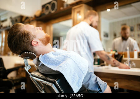 Cheveux homme recevant un traitement dans la barbe barbier Banque D'Images