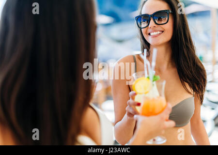 Cheerful female friends drinking cocktails en été et smiling Banque D'Images