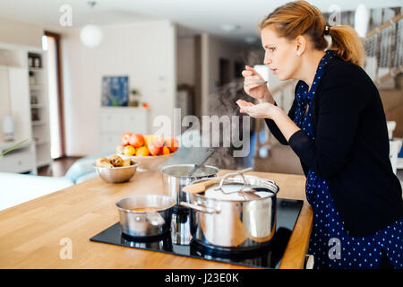 Femme au foyer cuisine dans une cuisine moderne Banque D'Images