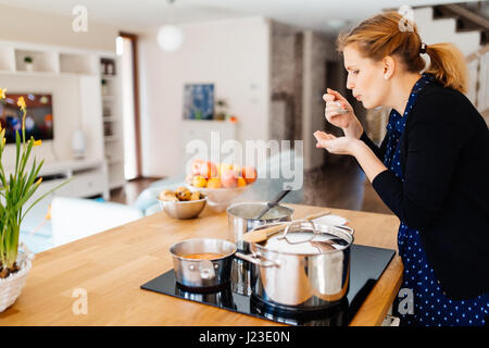 Femme au foyer cuisine dans une cuisine moderne Banque D'Images