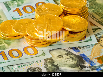 Pile de American Gold Eagle Gold Bullion coins sur nouveau design de devises américaines 100 dollar bills