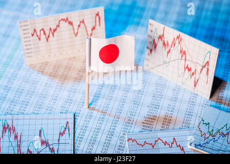 Drapeau japonais avec des tables de taux et graphiques pour le développement économique. Banque D'Images