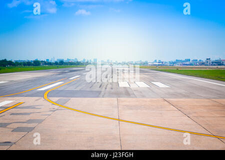 Piste de l'aéroport international de Bangkok, Thaïlande, d'atterrissage dans le terminal de l'aéroport avec marquage sur fond bleu ciel avec la lumière du soleil. Banque D'Images