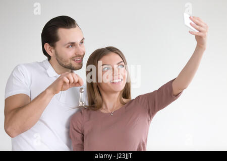 Couple photo portrait selfies avec clés de l'appartement sur smart Banque D'Images