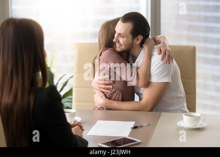 Happy young couple hugging on rencontre avec l'agent immobilier Banque D'Images