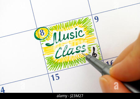 La femme à la plume l'écriture dans la classe de musique rappel calendrier. Banque D'Images