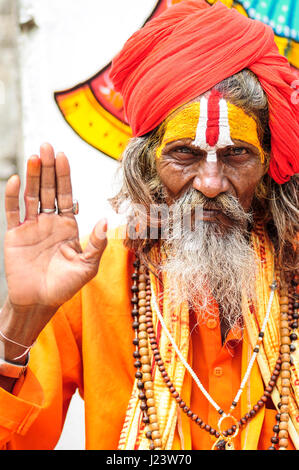 Udaipur, Inde, le 14 septembre 2010 : saint homme en oragne clothes holding sa main vers le haut. Banque D'Images