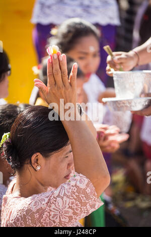 Kesiman, Denpasar, Bali, Indonésie. Apr 23, 2017. Femme balinaise habillé en tenue de cérémonie tient ses mains au-dessus de la tête en position de prière tout en priant pendant la cérémonie religieuse d'Pengerebongan hindou, une cérémonie balinaise qui a lieu une fois tous les 210 jours sur le calendrier Saka hindous balinais qui implique les offrandes, prières et bénédictions à l'Hindu Temple de Pura Petilan. Kesiman, Denpasar, Indonésie. Crédit : Antony Ratcliffe/Alamy Live News. Banque D'Images