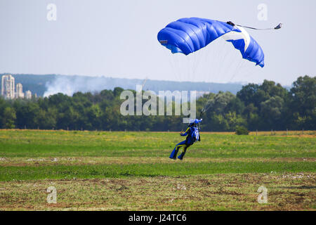 Le parachutiste à l'atterrissage sur l'aérodrome d'herbe. Banque D'Images