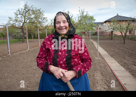 Femme vêtue de vêtements traditionnels de la région de Moravie du sud de la République tchèque se trouve dans son jardin Banque D'Images