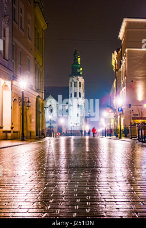 Nuit dans la rue, Pologne. L'éclairage de nuit en raison de la chaussée de pierre humide de la vieille ville. Belle photo de fond. Banque D'Images