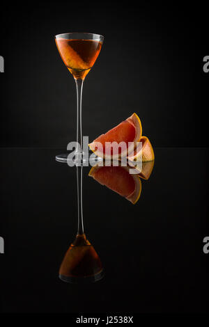 Cognac lentement brassé avec Cocchi Americano, apple et liqueur bitters pamplemousse. Servi dans une petite coupétte et garnie d'un pamplemousse rose Banque D'Images