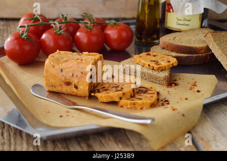 Le beurre fait maison avec les tomates séchées au soleil pour s'étend sur un papier cuisson. Concept d'aliments sains. Banque D'Images