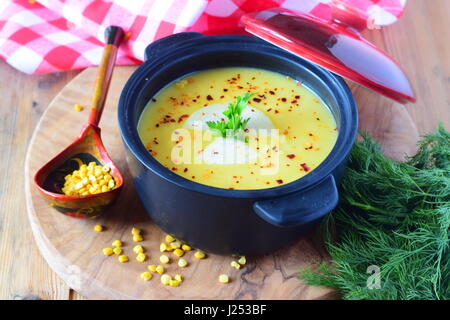 Bouillie de pois dans un pot noir sur un fond de bois. L'alimentation saine, de l'alimentation pour le serrage. Banque D'Images