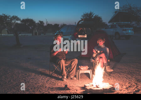 Fun pour adultes in camping par nuit. Aventure en National Park, Afrique du Sud. Brûler un feu de camp et tente dans l'arrière-plan. La tonalité de l'image. Banque D'Images