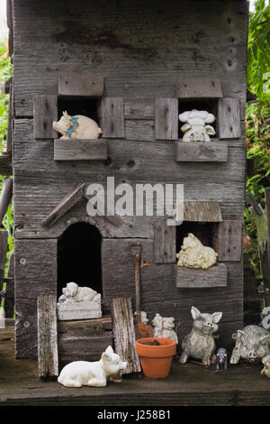Close-up d'une vieille maison en bois avec des figurines d'animaux de ferme miniature dans un jardin résidentiel paysagé en été Banque D'Images
