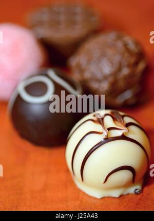 Un gros plan de divers pralinés chocolat belge sur fond de bois. Banque D'Images