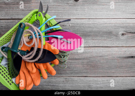 Outils de jardin et des gants sur les planches de bois. Banque D'Images