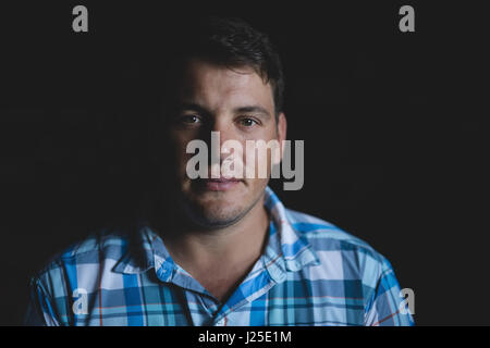 Portrait de l'homme confiant sur fond noir Banque D'Images