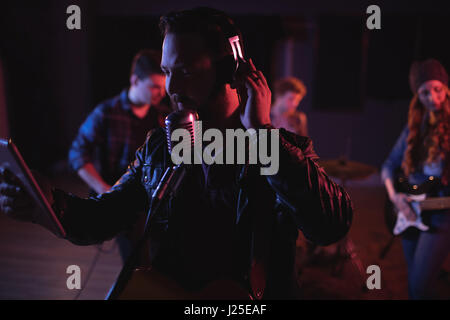 Man singing on retro microphone en studio d'enregistrement Banque D'Images
