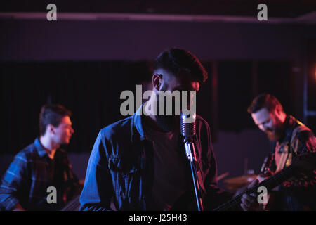 Cose-up du guitariste qui joue de la guitare et chanter dans le studio d'enregistrement Banque D'Images