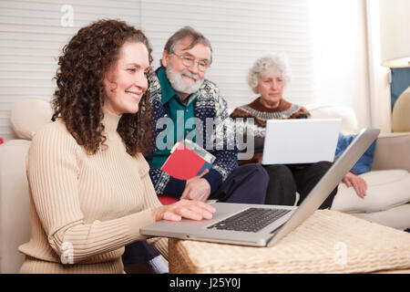 Un tir d'une famille de passer du temps à la maison avec un ordinateur portable Banque D'Images