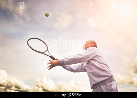 La prise d'un senior asian man playing tennis Banque D'Images