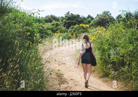 Young Woman Walking Along Path in Field, Kamenjak National Park, Premantura, Croatia Banque D'Images