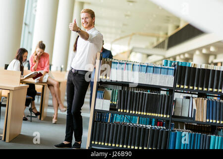 Groupe de jeunes gens qui étudient la lecture et l'éducation elles-mêmes dans la bibliothèque Banque D'Images