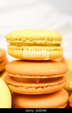 Pile de Biscuits macaron orange et jaune isolé sur blanc. Banque D'Images