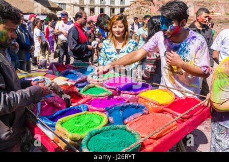 Un jeune homme, enduit de couleur, est l'achat de poudre de couleur pour le festival holi Banque D'Images
